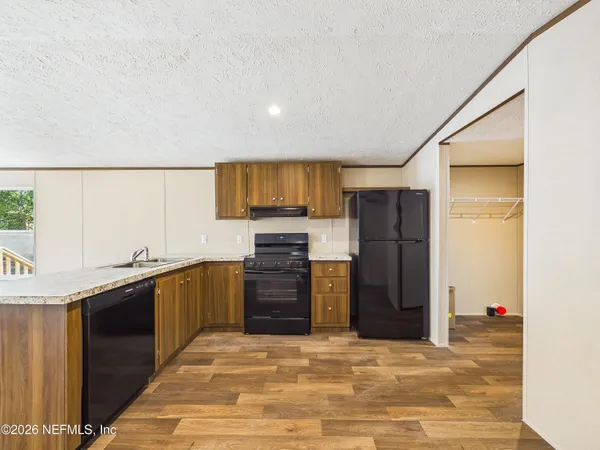a kitchen with stainless steel appliances granite countertop a refrigerator and a sink