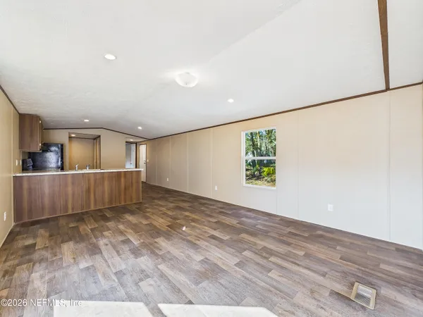 a view of a big room with wooden floor and windows