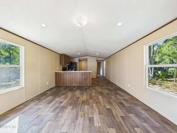 a view of a big room with wooden floor and windows