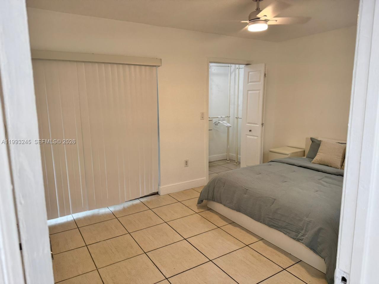 1910 Southwest 17th Avenue, Unit 4 Miami, FL 33145 - Photo 11 of 19 a bedroom with a bed and a chandelier fan