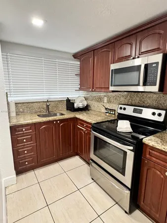a kitchen with stainless steel appliances granite countertop a stove microwave and cabinets