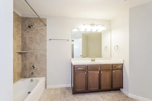 a bathroom with a tub sink and mirror