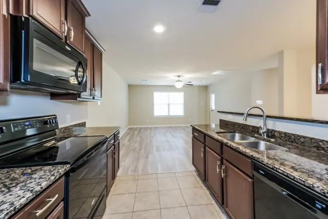 a kitchen with granite countertop stainless steel appliances and sink