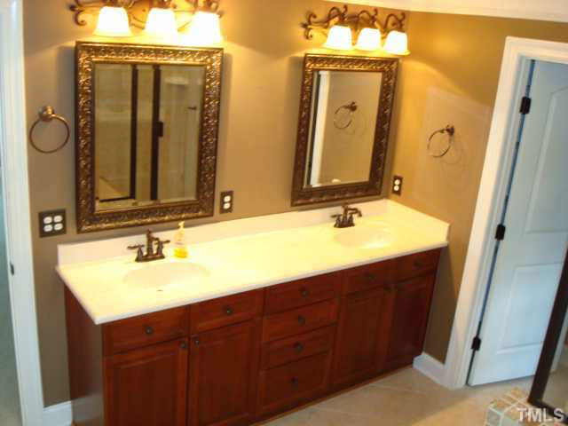 7203 Newport Avenue Raleigh, NC 27613 - Photo 19 of 24 a bathroom with a double vanity sink and a mirror
