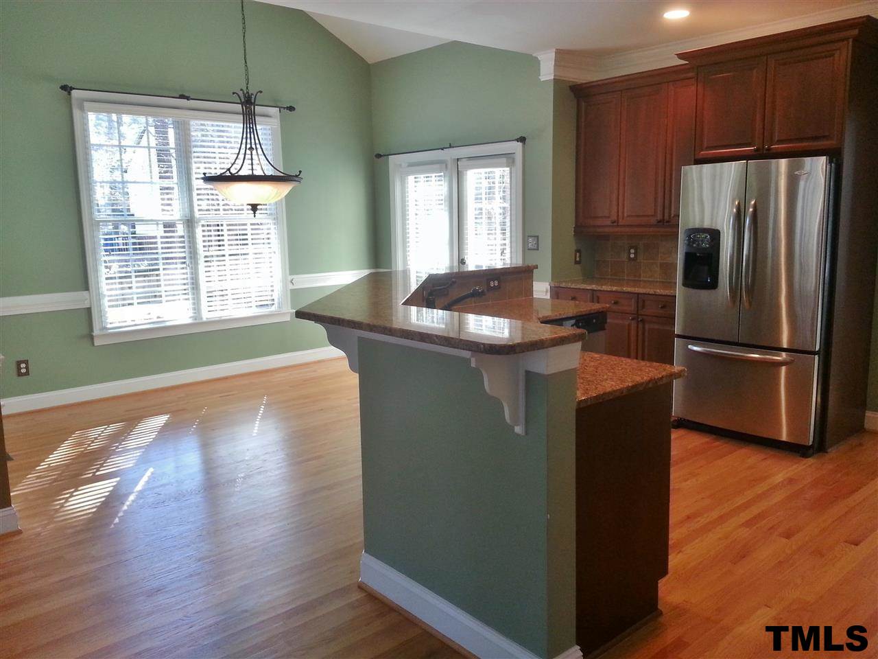 7203 Newport Avenue Raleigh, NC 27613 - Photo 5 of 24 a kitchen with kitchen island a sink and a refrigerator