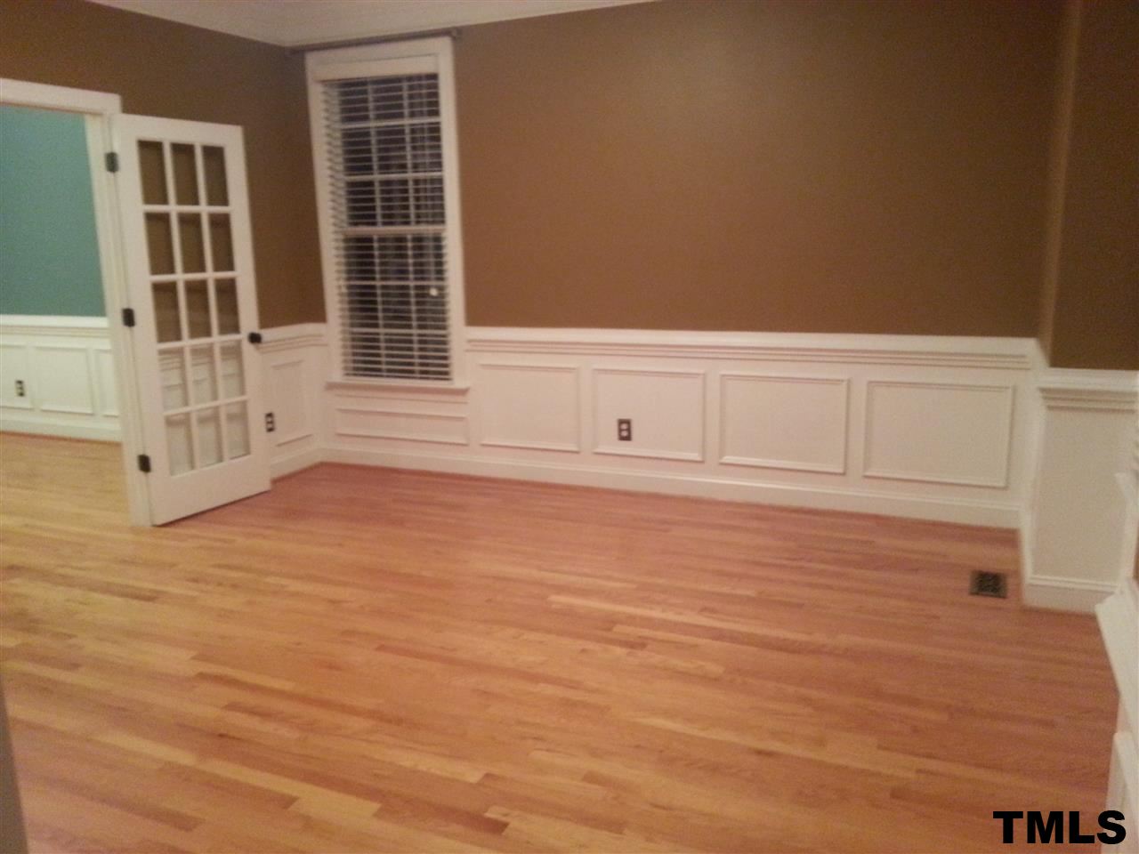 7203 Newport Avenue Raleigh, NC 27613 - Photo 8 of 24 an empty room with wooden floor and windows
