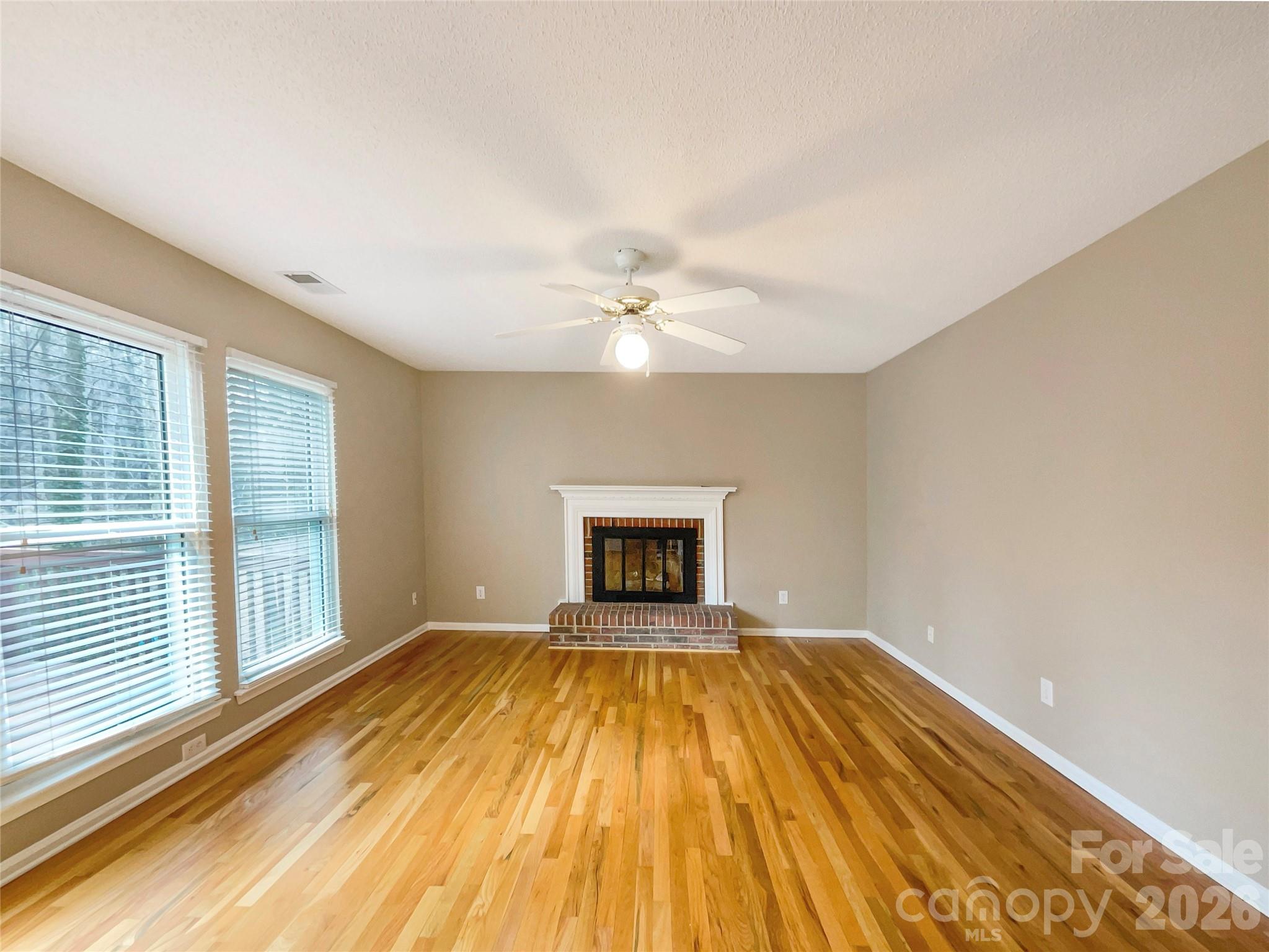 231 Fox Hollow Road Mooresville, NC 28117 - Photo 15 of 20 an empty room with a fireplace and windows