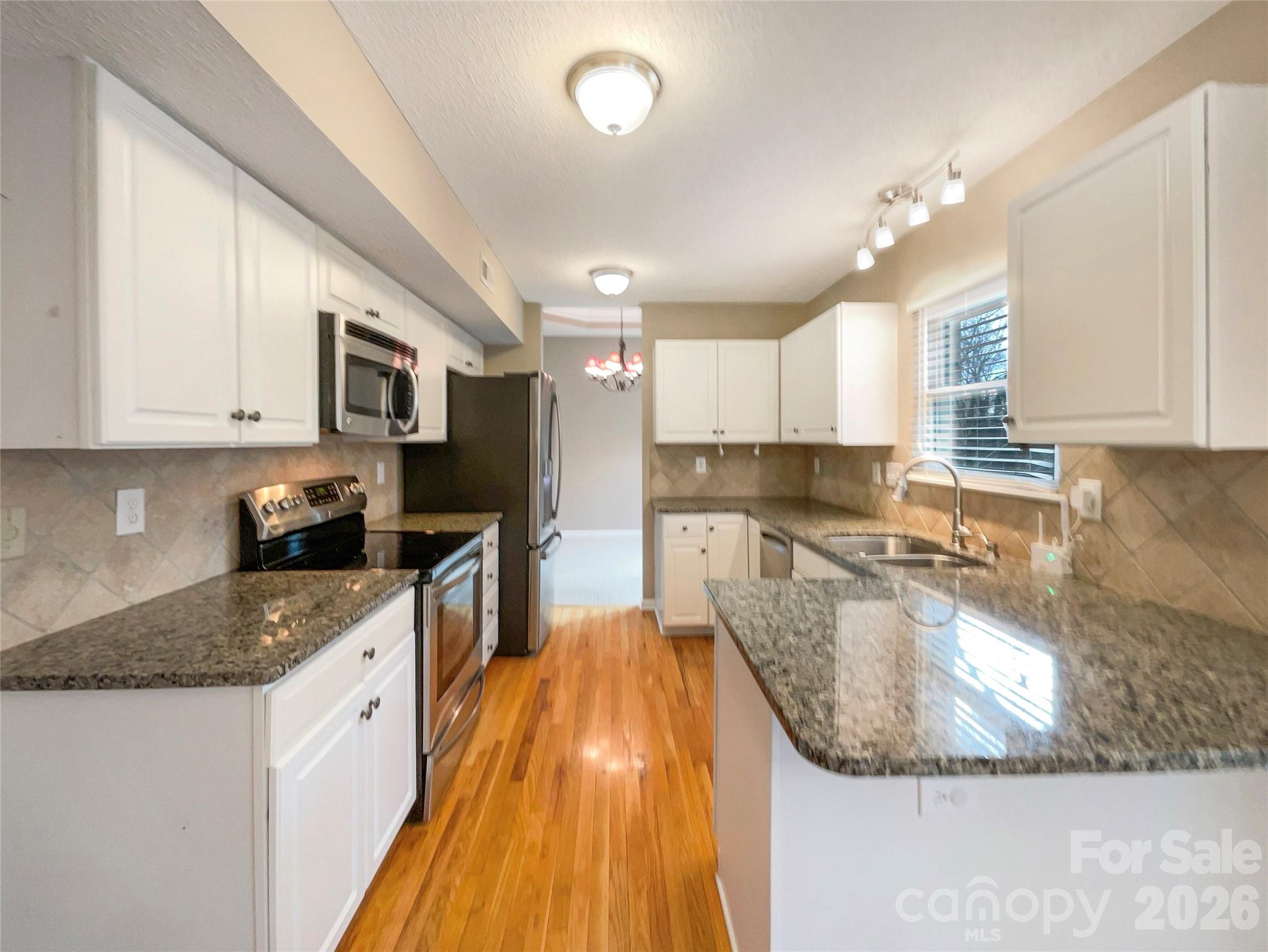 231 Fox Hollow Road Mooresville, NC 28117 - Photo 2 of 20 a large kitchen with kitchen island granite countertop a sink a stove top oven a counter space and cabinets
