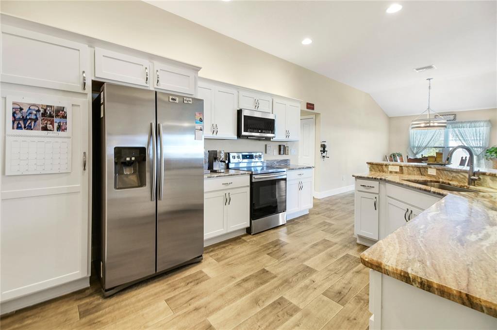 3323 Rohan Road Oxford, FL 34484 - Photo 15 of 46 a kitchen with stainless steel appliances granite countertop a refrigerator a stove and a sink