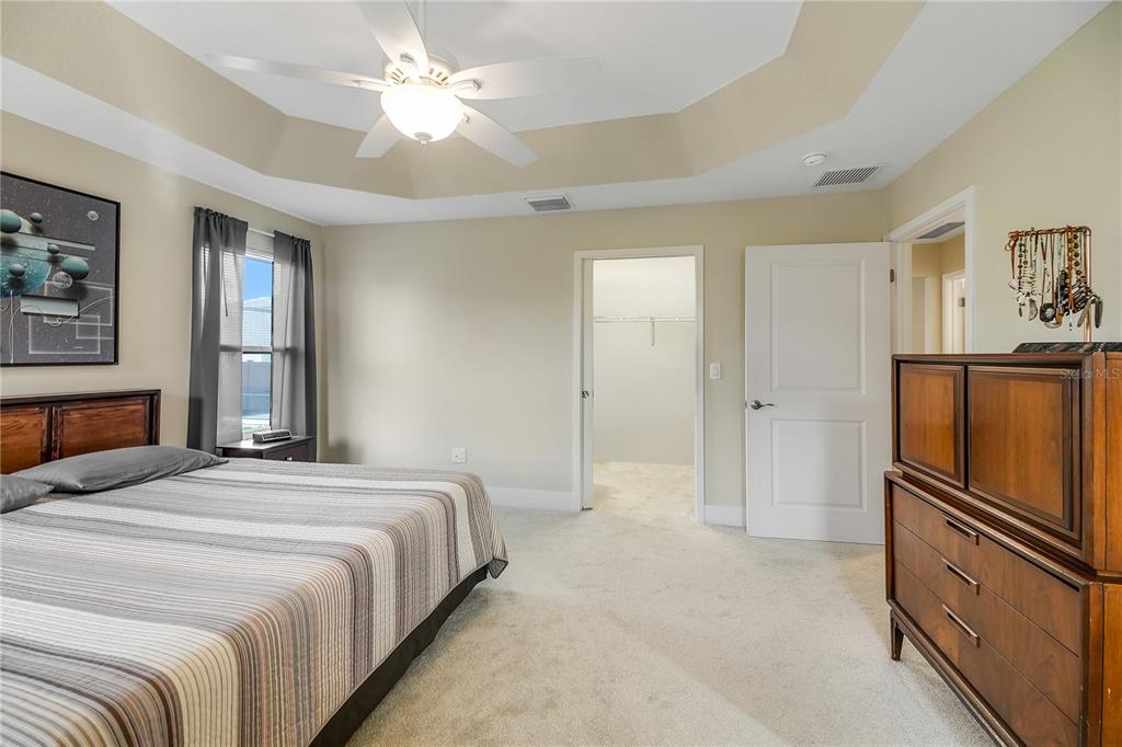 3323 Rohan Road Oxford, FL 34484 - Photo 21 of 46 a spacious bedroom with a bed and a chandelier