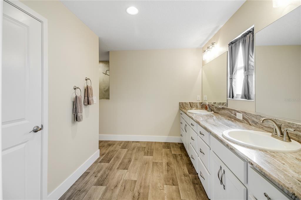 3323 Rohan Road Oxford, FL 34484 - Photo 24 of 46 a bathroom with a granite countertop sink toilet and shower