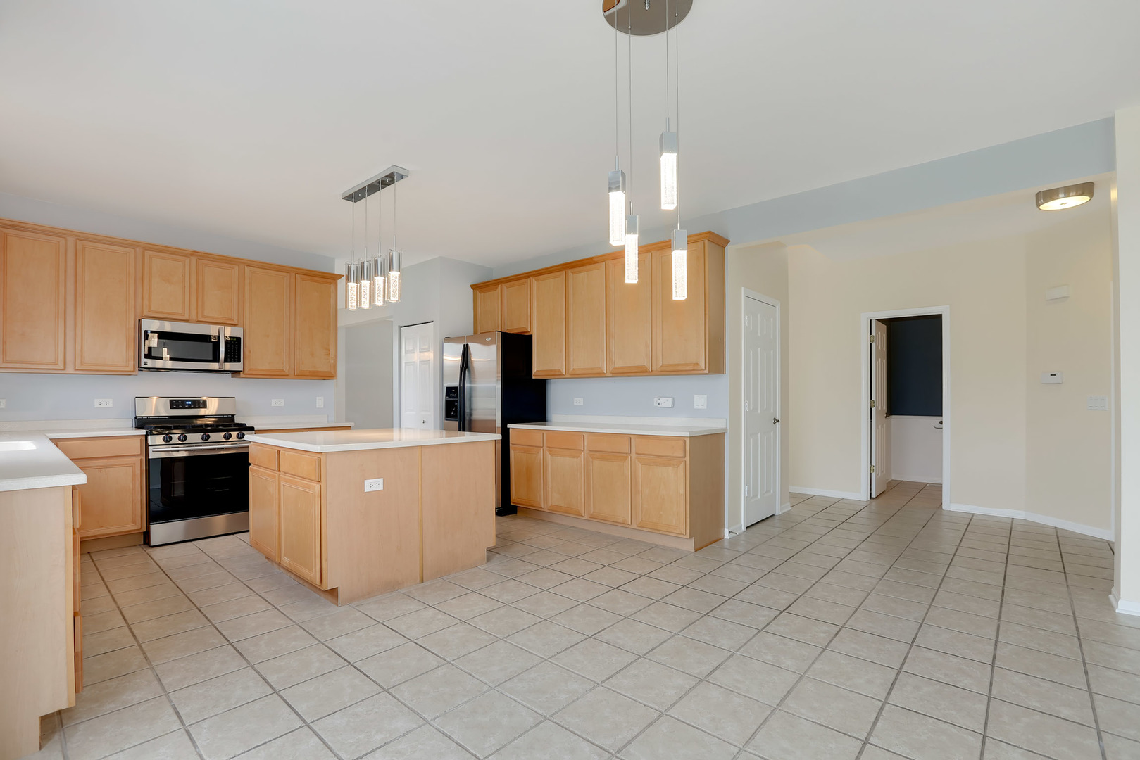 1786 Prairie Ridge Circle Lindenhurst, IL 60046 - Photo 13 of 34 a large kitchen with stainless steel appliances a stove a sink a microwave and cabinets