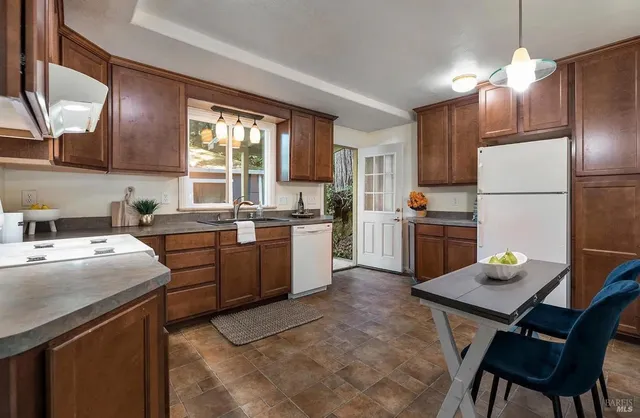 a kitchen with a dining table chairs refrigerator and cabinets