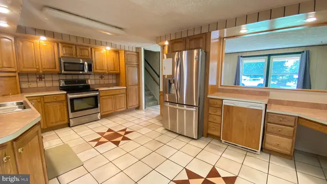 a kitchen with granite countertop a refrigerator and a stove top oven