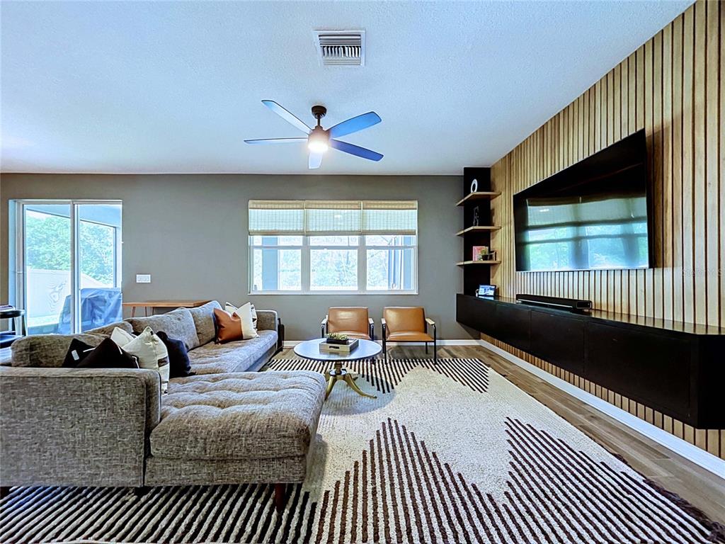 18078 Romanesque Court Spring Hill, FL 34610 - Photo 25 of 81 a living room with furniture a flat screen tv and a large window