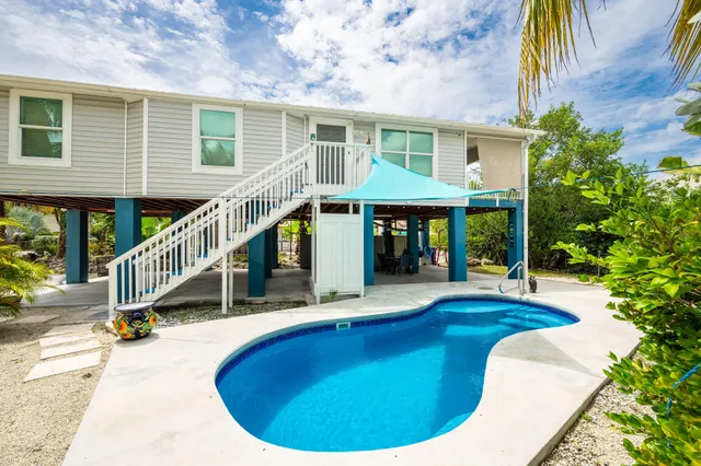 a view of house with swimming pool outdoor seating