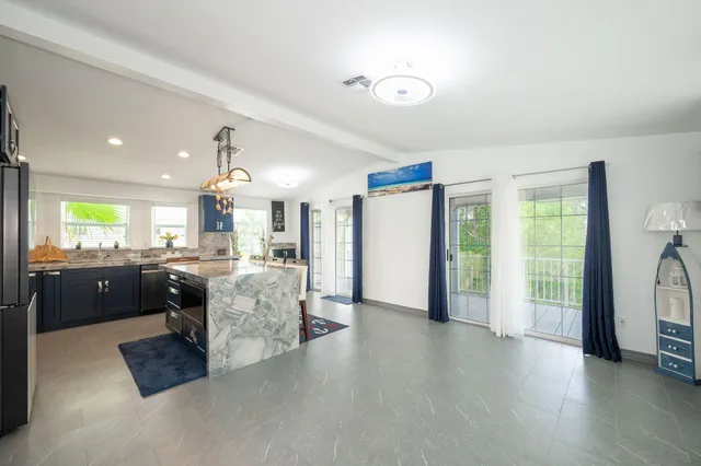 a large living room with stainless steel appliances kitchen island granite countertop furniture and a kitchen view