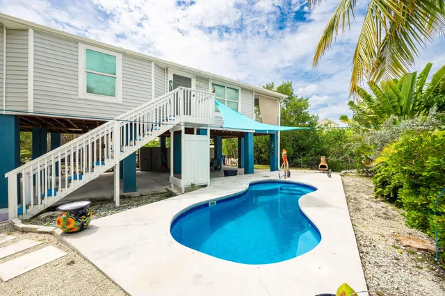 a view of a house with pool and sitting area