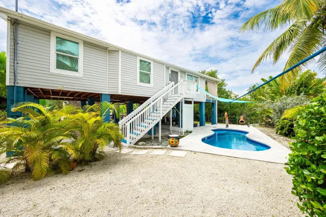 a view of a house with swimming pool and sitting area