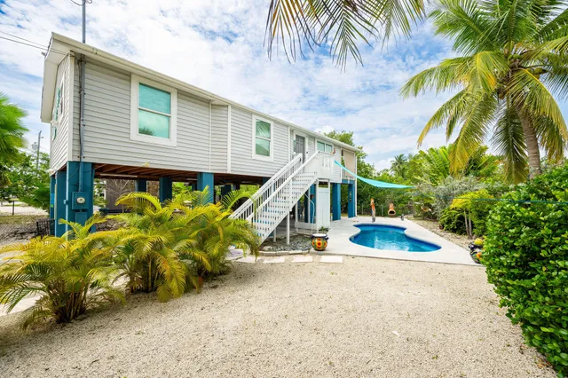 a view of a house with swimming pool and sitting area