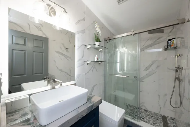 a bathroom with a sink shower and a mirror