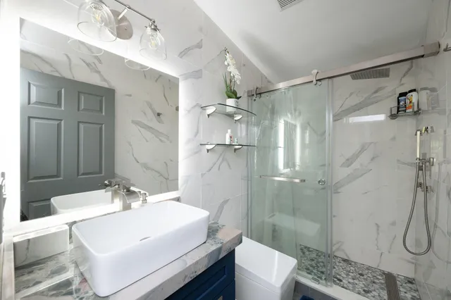 a bathroom with a sink a toilet and shower