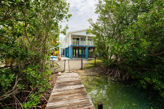a view of a house with potted plants and a bench