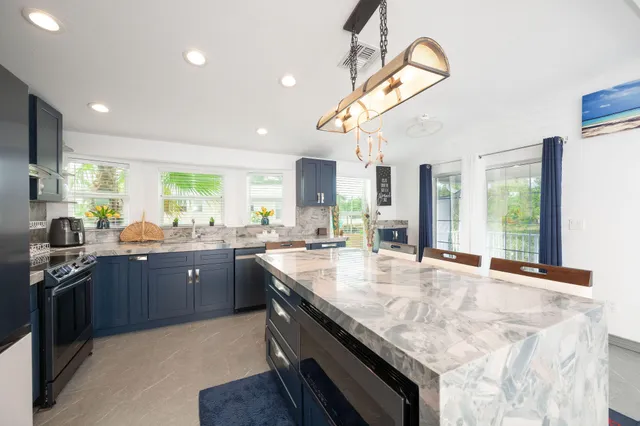 a kitchen with stainless steel appliances granite countertop sink stove and refrigerator