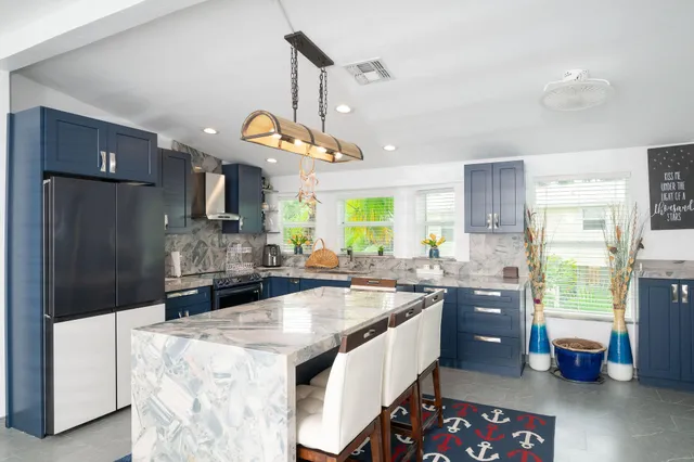 a kitchen with stainless steel appliances granite countertop a sink a stove and a refrigerator