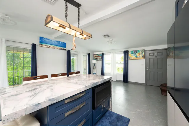a kitchen with kitchen island a sink appliances and a large window