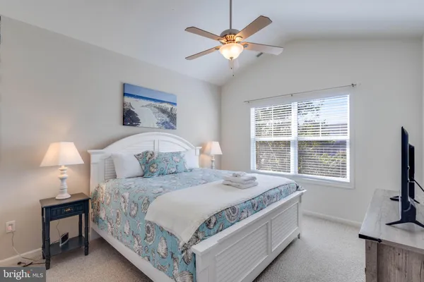 a bedroom with a bed a window and a flat screen television