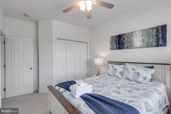 a bedroom with a bed and a painting on the wall