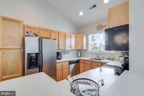 a kitchen with stainless steel appliances a sink cabinets and a refrigerator
