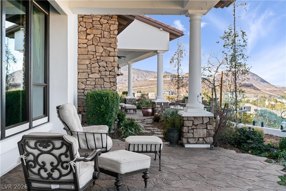 1123 Christian Road Henderson, NV 89002 - Photo 63 of 94 An inviting stone patio offers majestic mountain and desert views, perfect for relaxation.