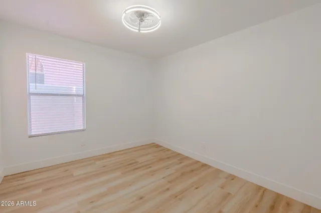 a bedroom with a white bed and a dresser