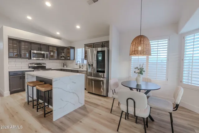 a kitchen with stainless steel appliances a dining table and chairs