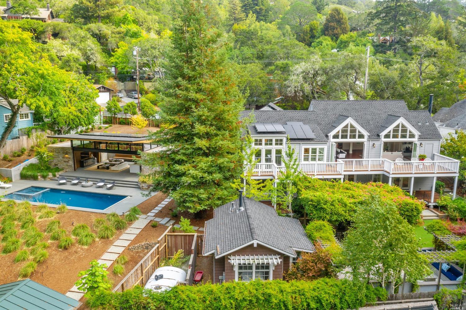 a aerial view of a house with swimming pool and large trees