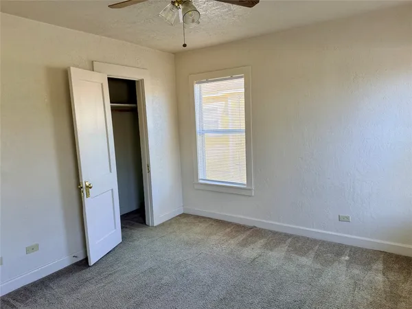 an empty room with windows and closet