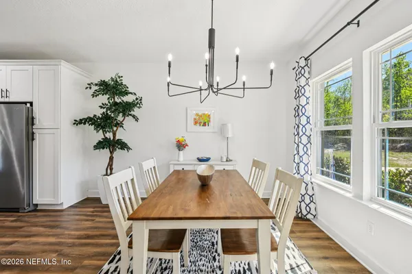 a kitchen with a refrigerator a stove top oven a sink dishwasher and white cabinets with wooden floor