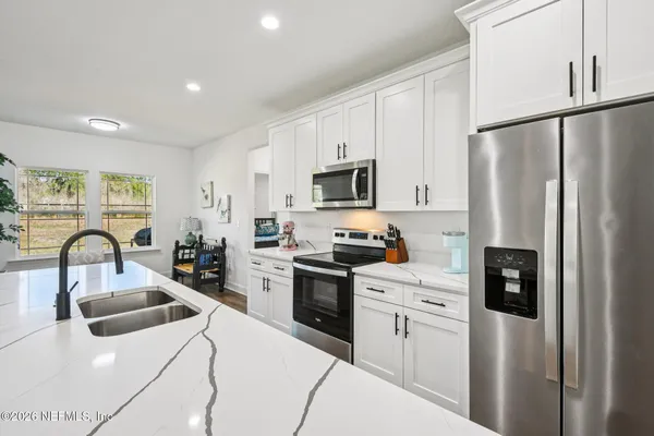 a kitchen with white cabinets and stainless steel appliances
