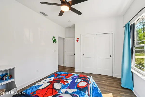 a bedroom with a bed and wooden floor
