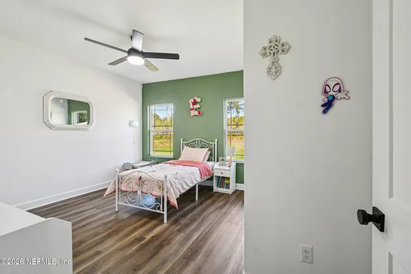 a view of a room with wooden floor and ceiling fan