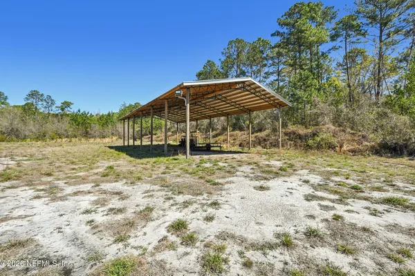 an aerial view of residential houses with outdoor space and trees