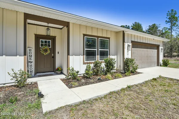 a living room with furniture kitchen view and a wooden floor