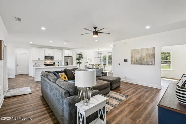 a dining room with furniture a chandelier and wooden floor