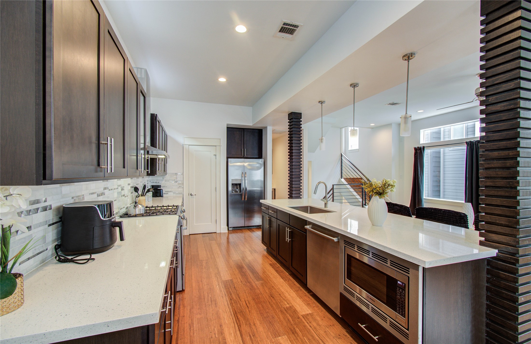4311 Marina Street Houston, TX 77007 - Photo 19 of 42 a large kitchen with stainless steel appliances a stove a sink dishwasher and a refrigerator with wooden floor