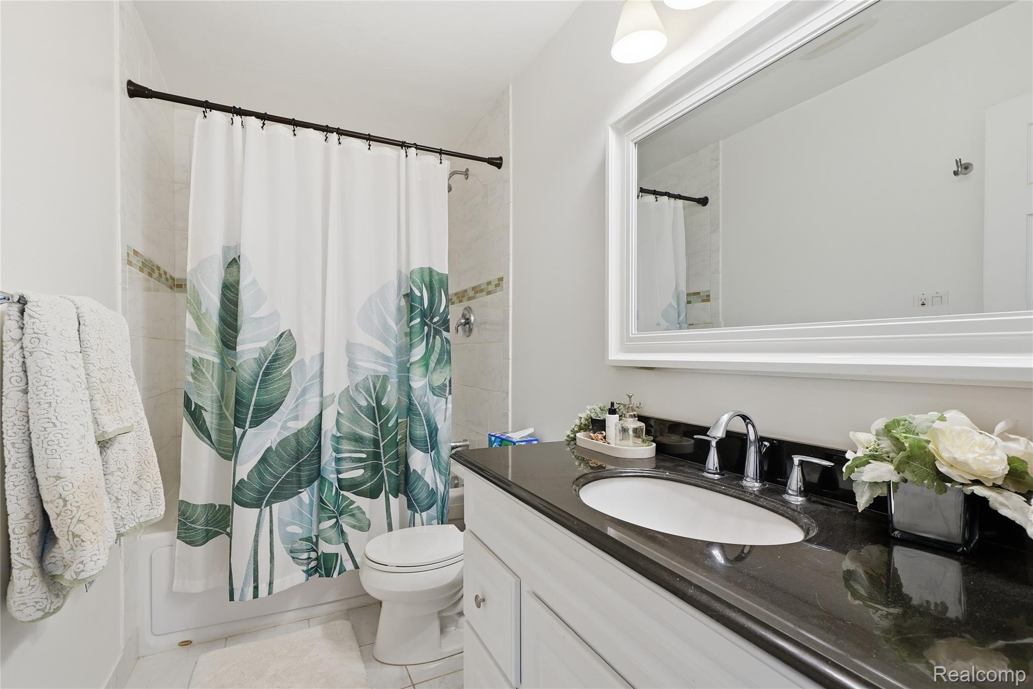 4041 West Maple Road, Unit E203 Bloomfield Hills, MI 48301 - Photo 21 of 25 Full bath featuring vanity, shower / bathtub combination with curtain, and light tile patterned flooring