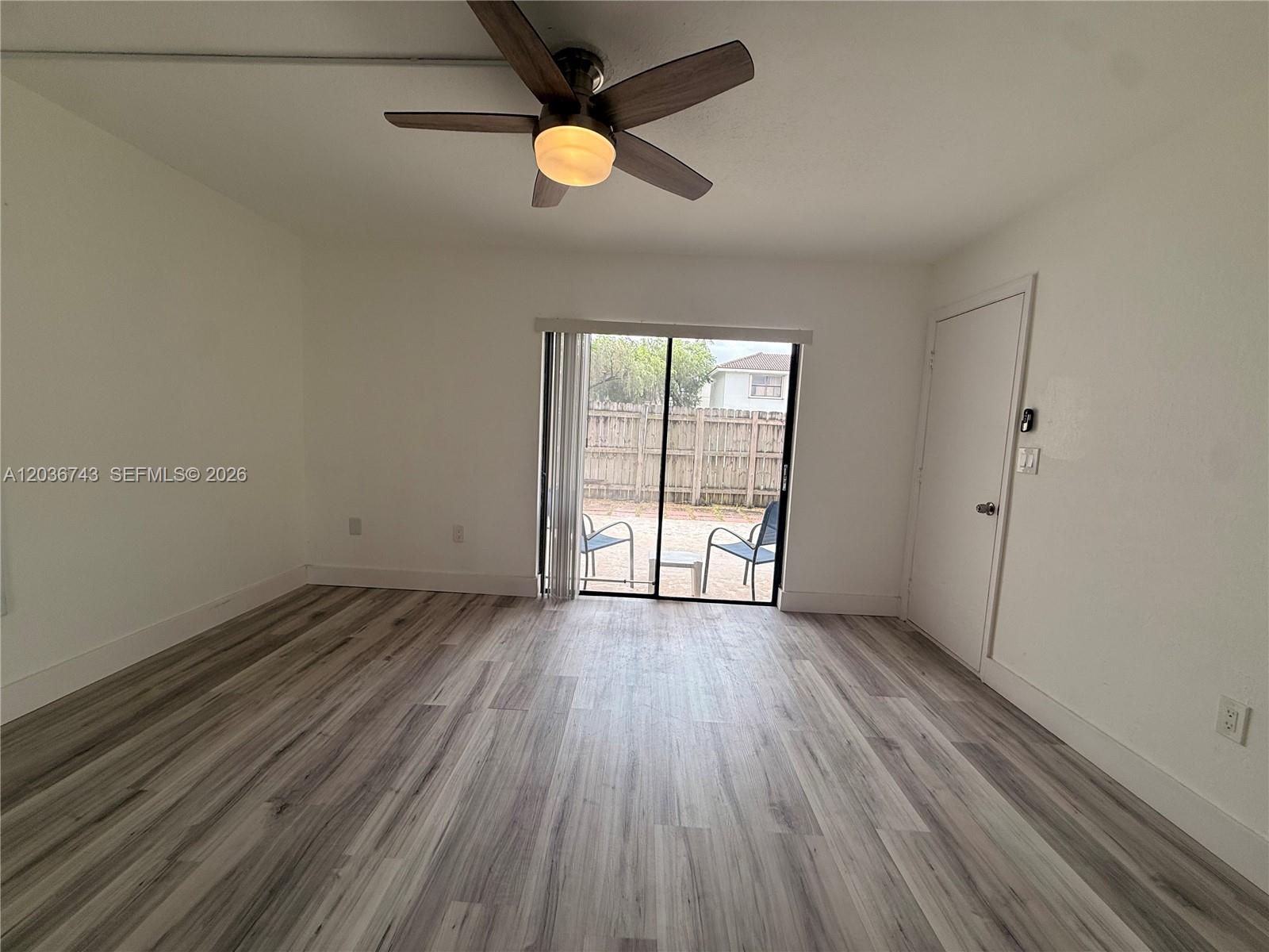 10875 Northwest 7th Street, Unit 1136 Miami, FL 33172 - Photo 18 of 25 an empty room with wooden floor fan and windows