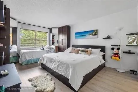 a bedroom with bed and a large window