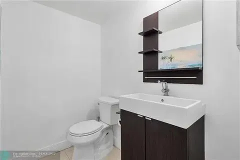 a bathroom with a sink toilet and mirror